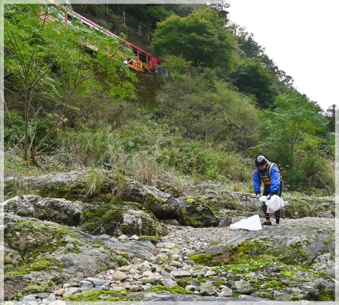 川原で大きな金属を拾う男性