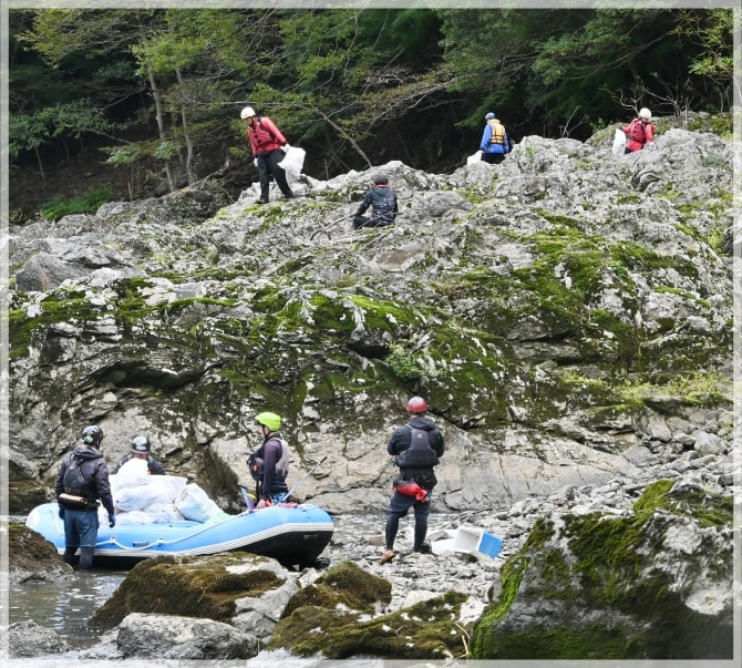 巨大な岩の上に登りゴミを拾う様子